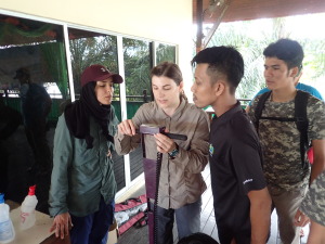 Emily demonstrates calibration technique with D.I. water while Fadwa, Jai and Inam look on.